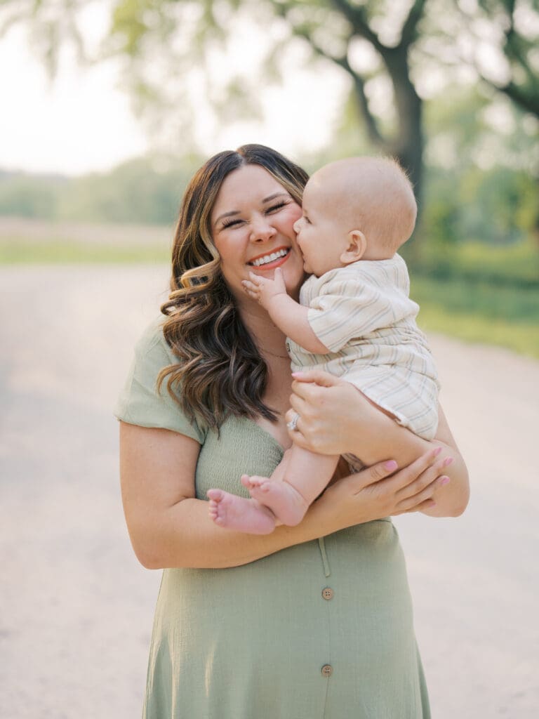 A photo with mom and her baby boy giving her a sloppy kiss during a session.
