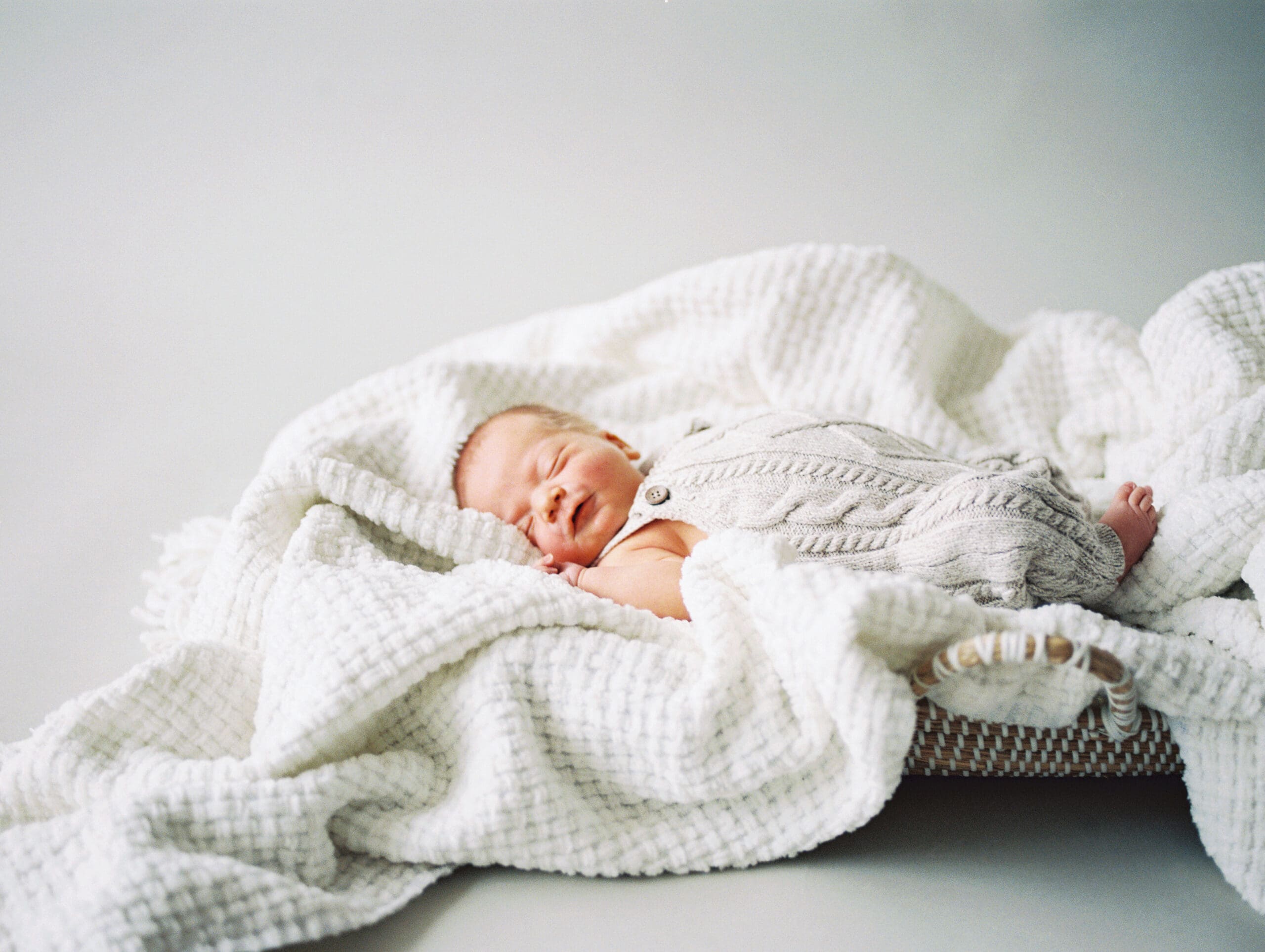 A newborn baby smiling during a studio session.